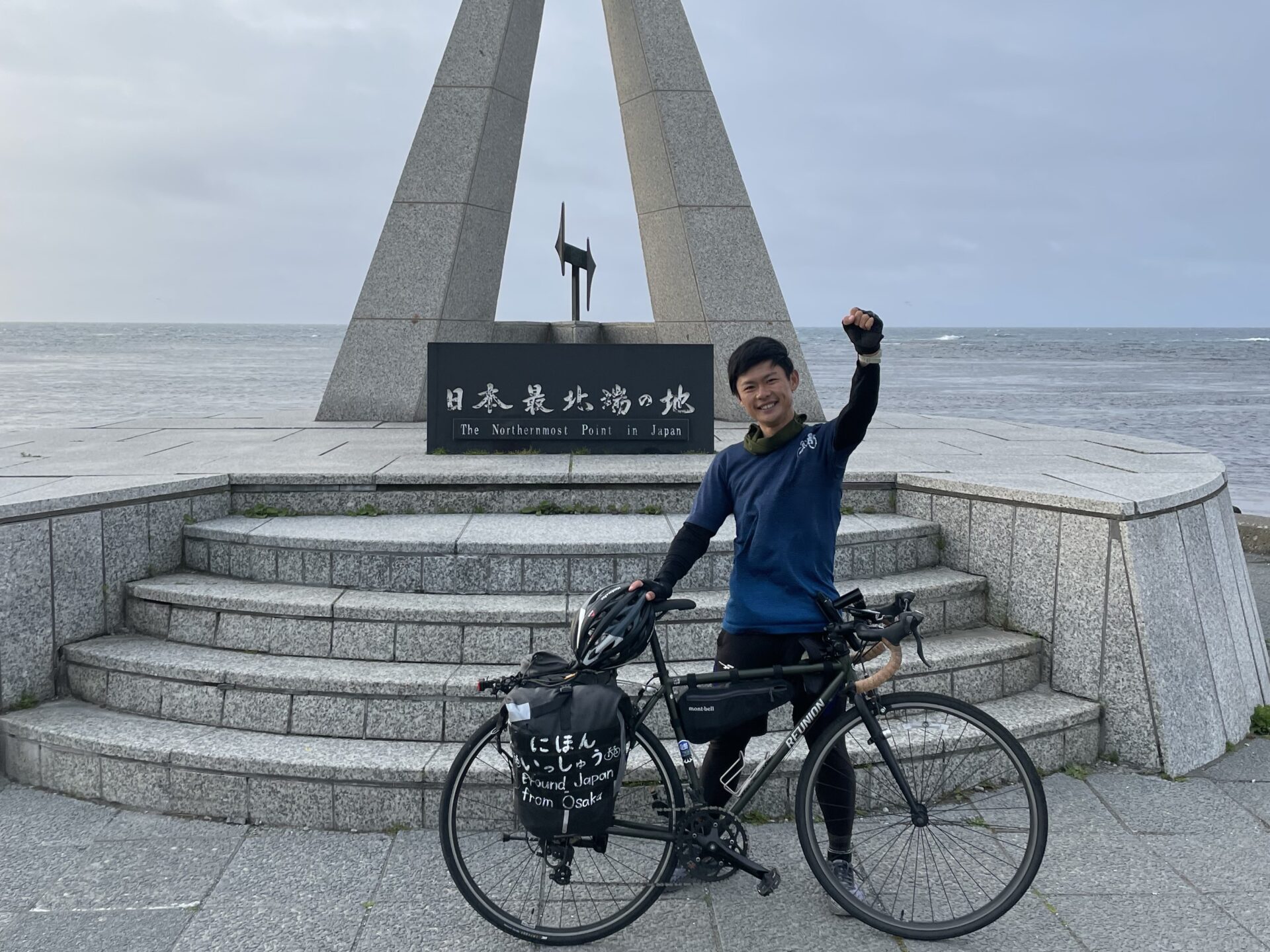 日本最北端の宗谷岬でポーズする旅人