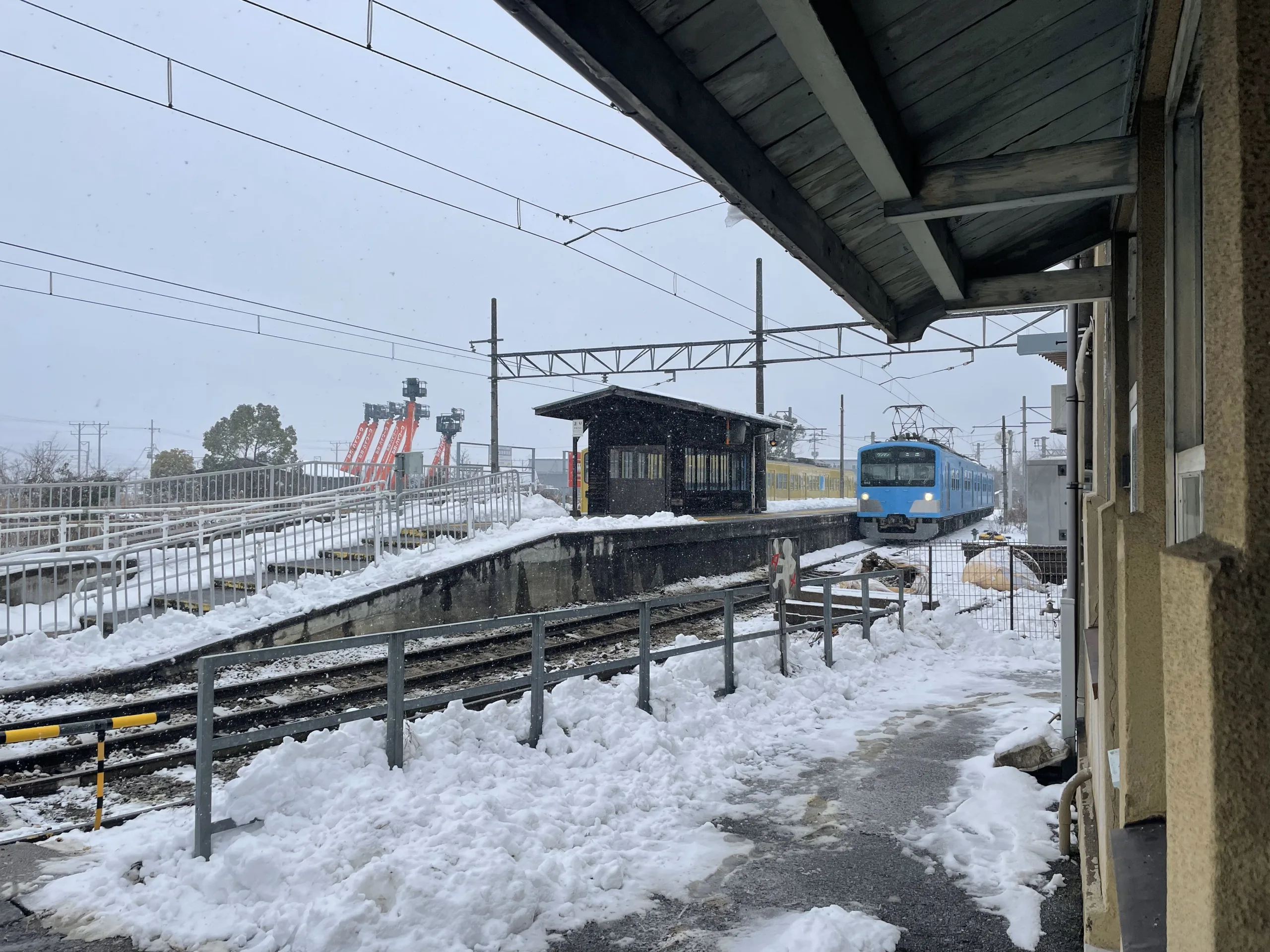 雪の鳥居本駅に到着する電車