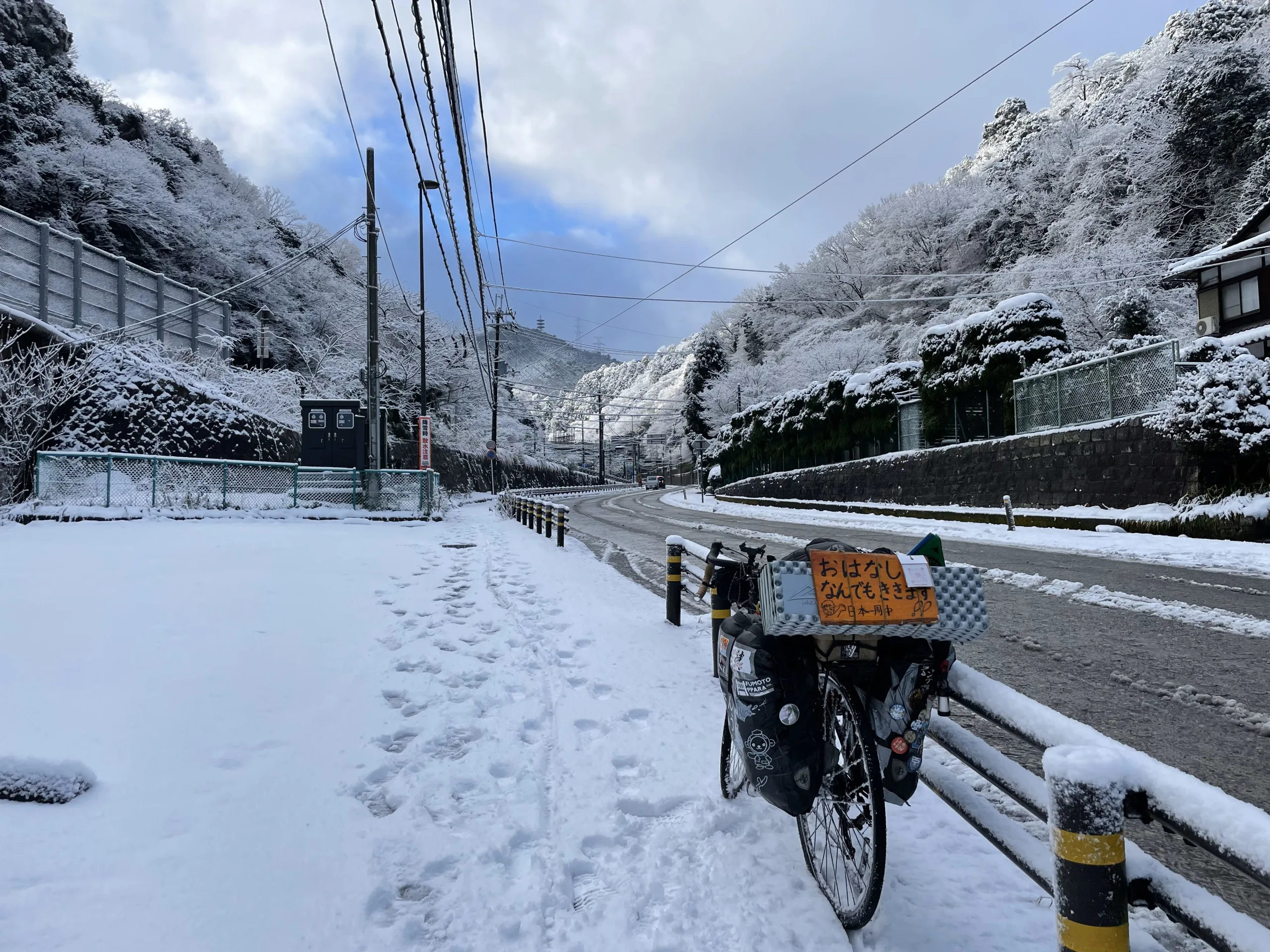 雪の逢坂の関を自転車で越える旅人