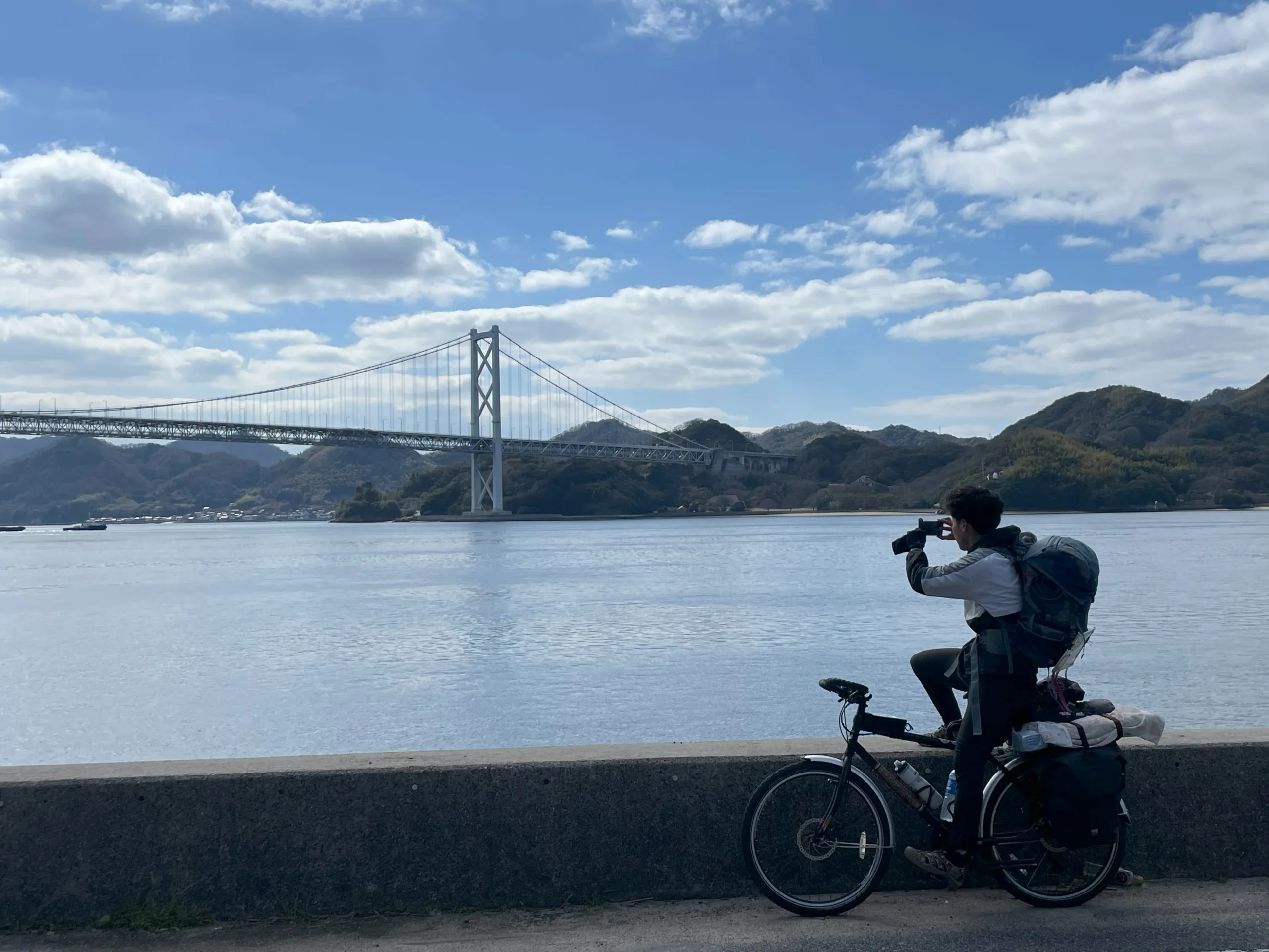 しまなみ海道で写真を撮る自転車の旅人