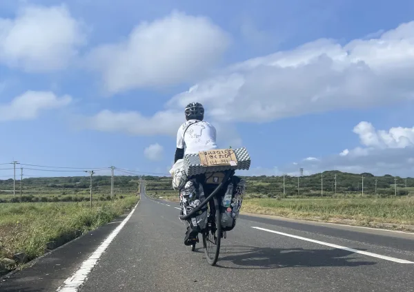 サトウキビの一本道で自転車と記念写真