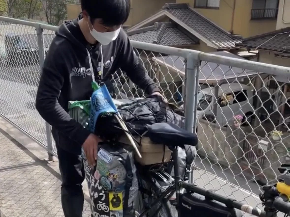 自転車に荷物を載せる旅人