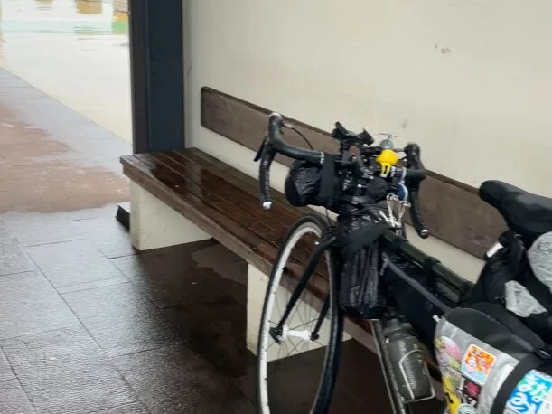 雨宿りする日本一周中の自転車