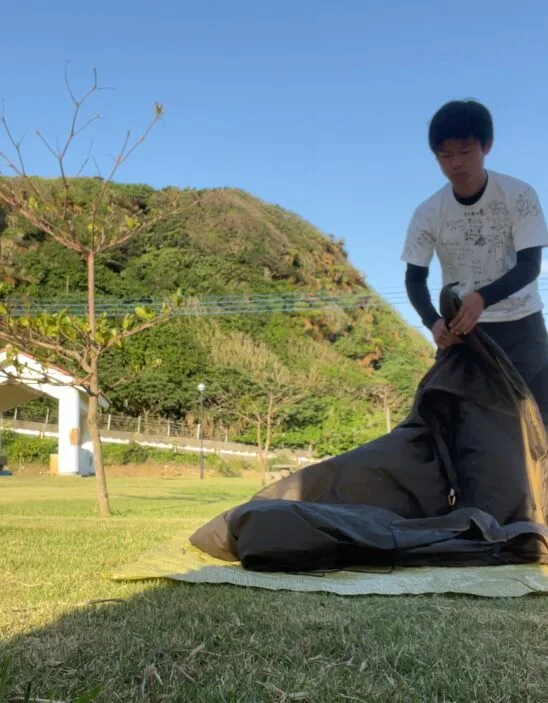 公園でテントを片付ける旅人