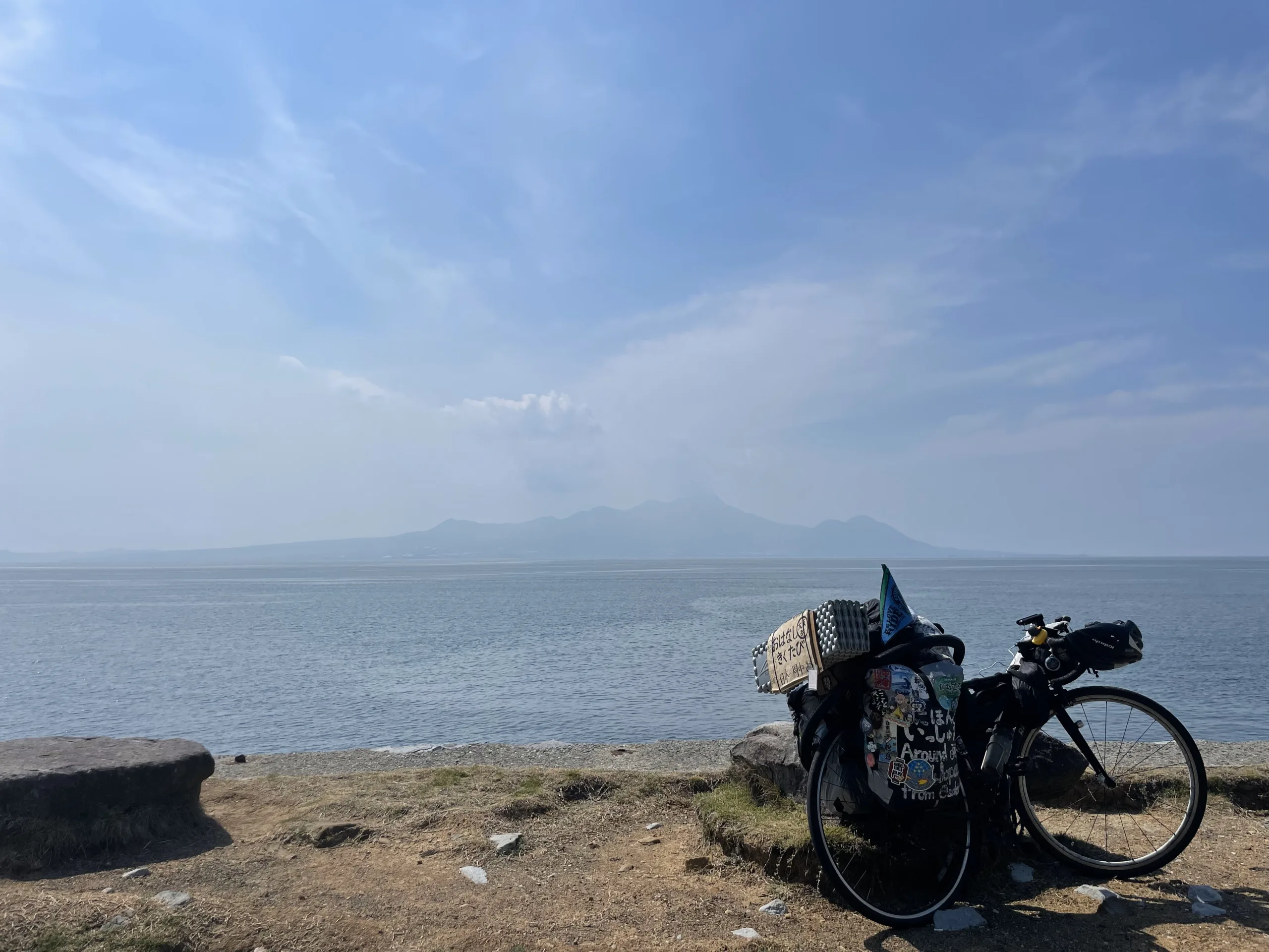 海の向こうに見える雲仙普賢岳と自転車