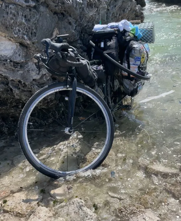 喜界島のハワイビーチで水に浸かる自転車