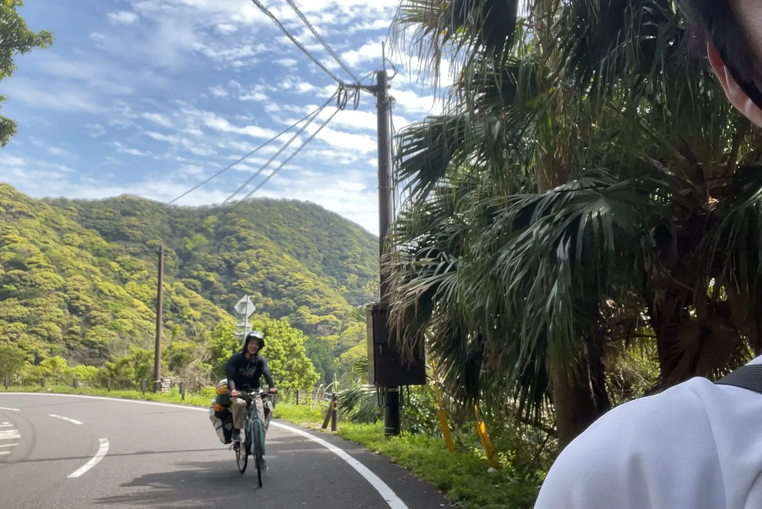 佐多岬で再会した旅人と山道をこぐ場面