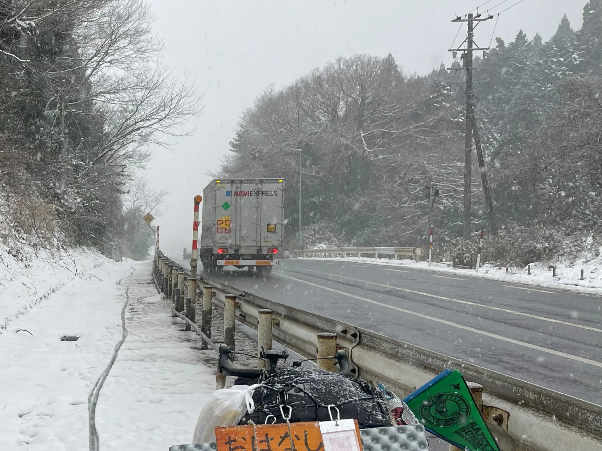 雪の中関が原を走るトラック
