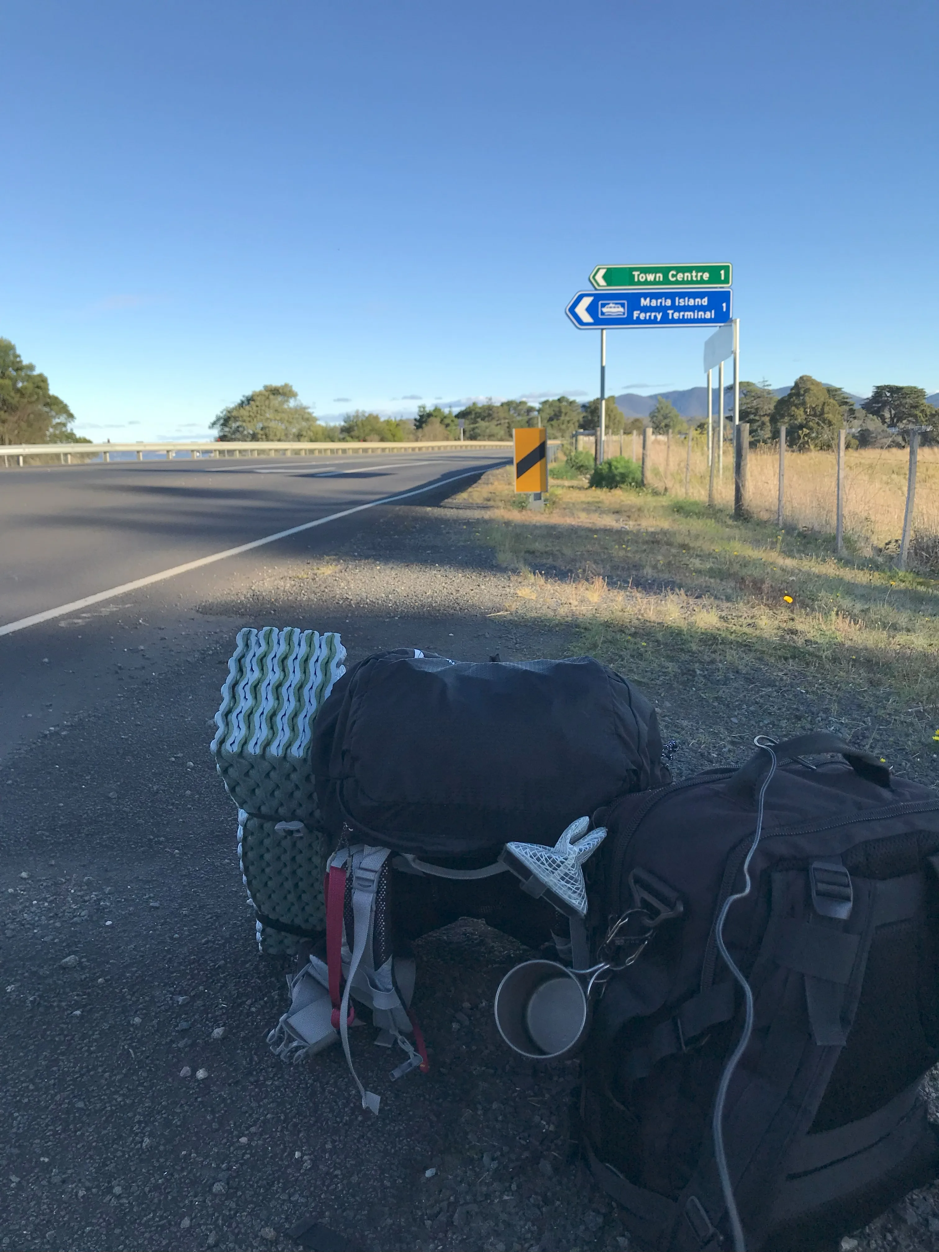 タスマニアのトリアバンナでヒッチハイクする旅人の荷物