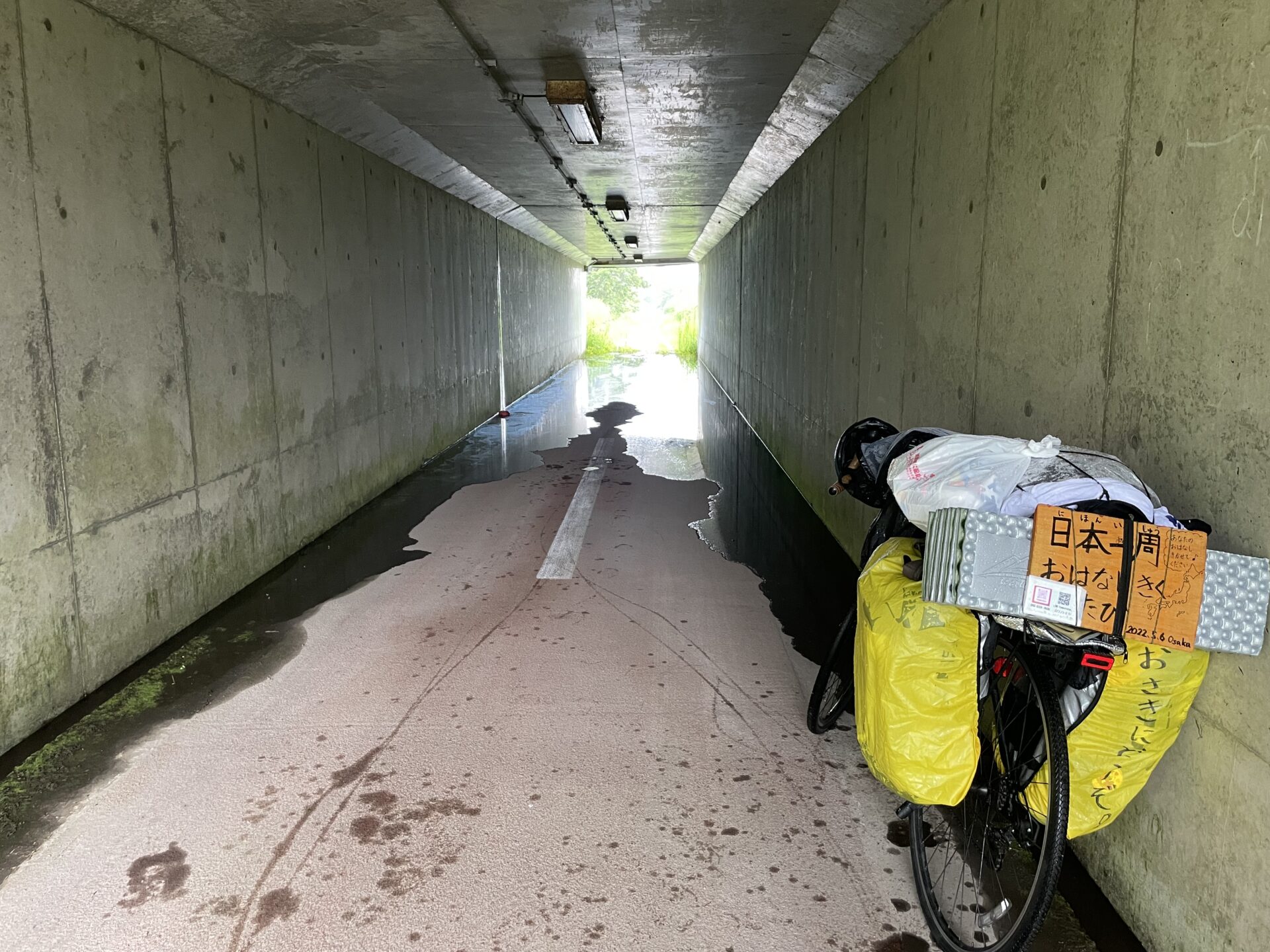 トンネルの中で雨宿りする日本一周の自転車
