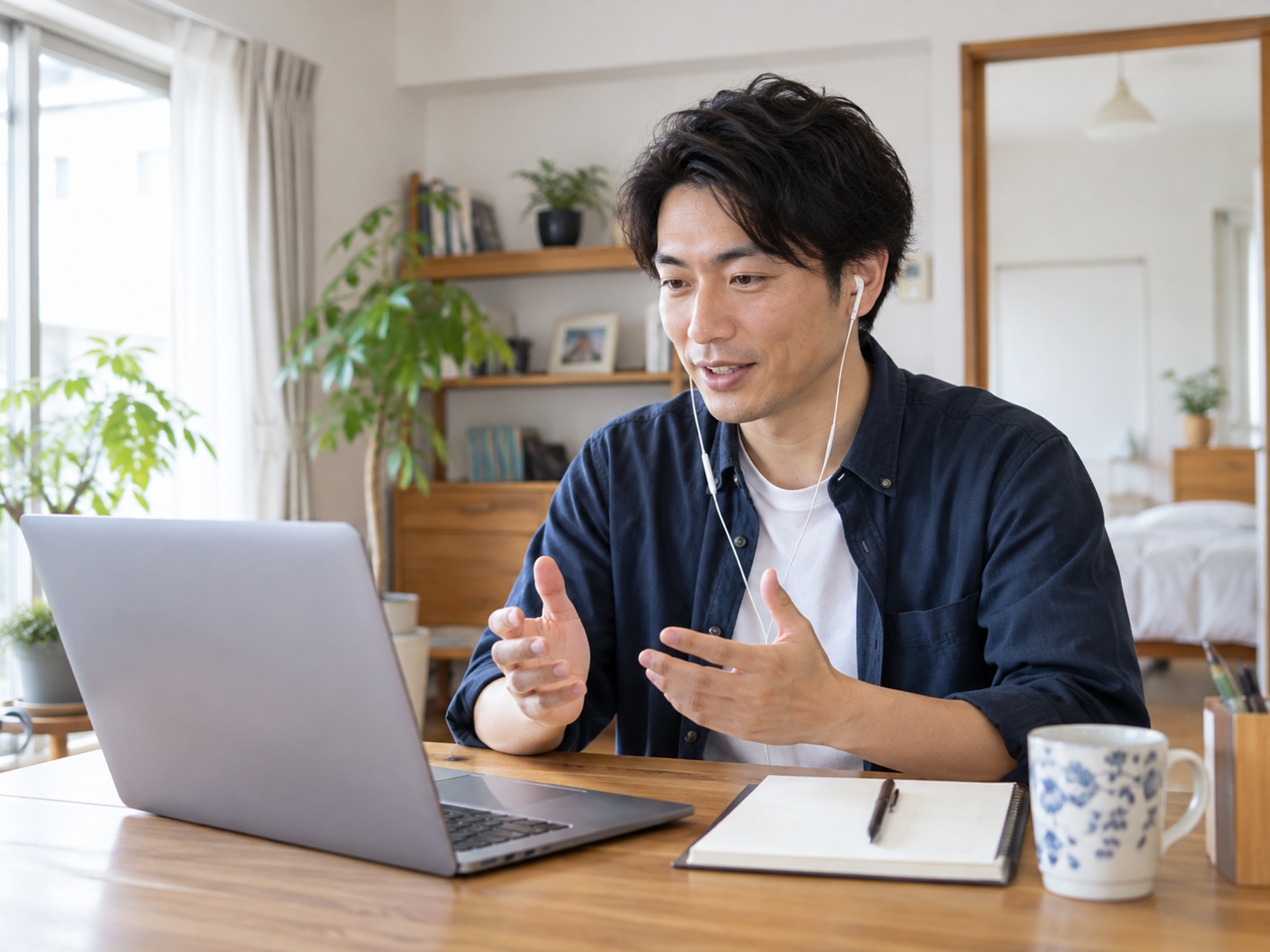 自宅のノートパソコンでオンライン日本語レッスンを行う30代男性
